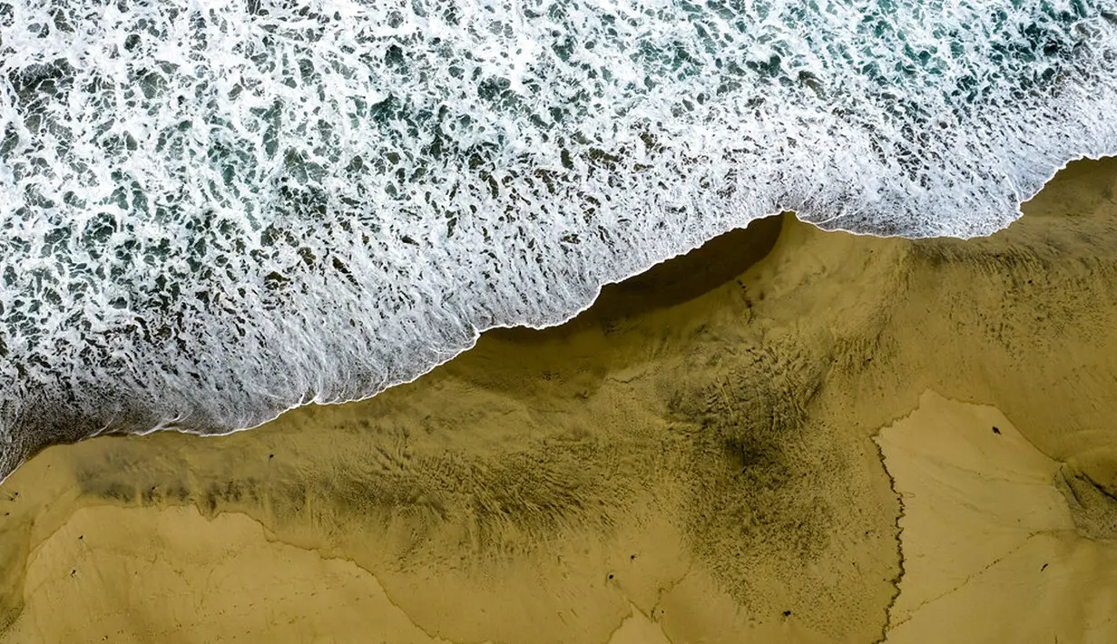 Foto udara menunjukkan pantai tercemar tumpahan minyak di Huntington Beach, California, Amerika Serikat, 4 Oktober 2021. Tumpahan minyak terjadi akibat kebocoran pipa pengebor minyak. (AP Photo/Ringo H.W. Chiu)