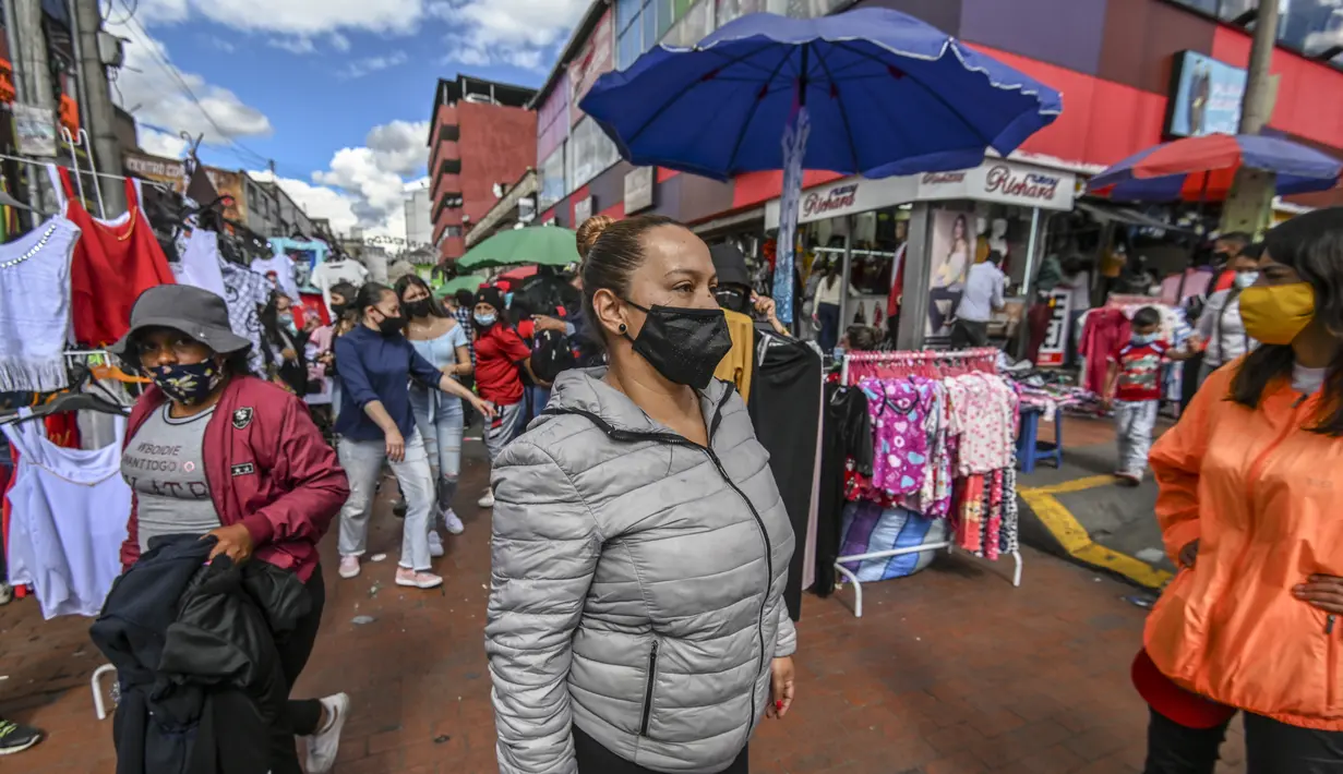 Orang-orang berbelanja hadiah Natal di jalan komersial di San Victorino, Bogota, Kolombia, Senin (21/12/2020). Kolombia, pada pekan lalu, kasus virus corona COVID-19 yang dikonfirmasi setiap harinya telah mencapai level tertinggi sejak pertengahan Agustus. (Juan BARRETO/AFP)