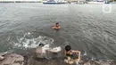 Anak-anak berenang di dermaga saat banjir rob merendam Pelabuhan Kali Adem, Muara Angke, Jakarta, Kamis (22/10/2020). Banjir rob yang merendam kawasan Pelabuhan Kali Adem sejak lima hari lalu dimanfaatkan oleh anak-anak setempat untuk berenang di sekitar dermaga. (merdeka.com/Iqbal S. Nugroho)