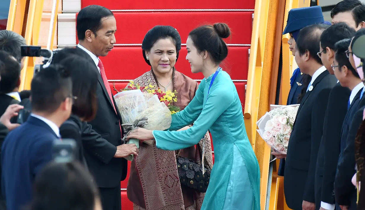 Presiden RI Joko Widodo dan istri Iriana Jokowi disambut di Bandara Internasional Vietnam menjelang KTT Kerjasama Ekonomi Asia Pasifik (APEC) di kota Danang, Vietnam, (10/11). (AFP PHOTO / Kamu Aung Thu)