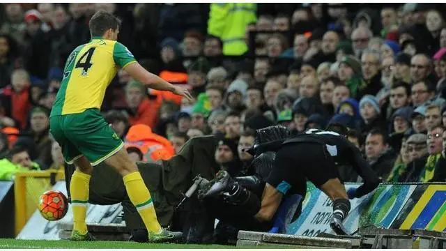 Penyerang Arsenal, Alexis Sanchez, terjerembab setelah didorong bek Norwich City, Ryan Bennett, dalam lanjutan kompetisi Premier League, Minggu (29/11/2015). 