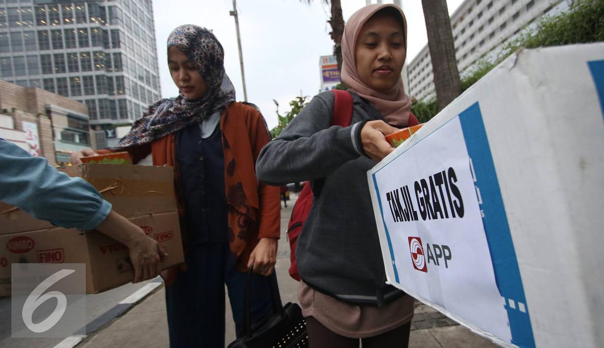 Karyawan Asia Pulp & Paper (APP) Sinar Mas membagikan takjil kepada pejalan kaki di kawasan Bundaran HI, Jakarta (24/6). (Liputan6.com/ Immanuel Antonius)