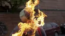 Patung bergambar Presiden Venezuela Nicolas Maduro dibakar oleh warga di Caracas , Venezuela, (27/3). Proses ini juga masuk dalam tradisi " Pembakaran Yudas " tetapi bedanya patung tersebut ditempel gambar Nicolas Maduro. (REUTERS / Marco Bello)