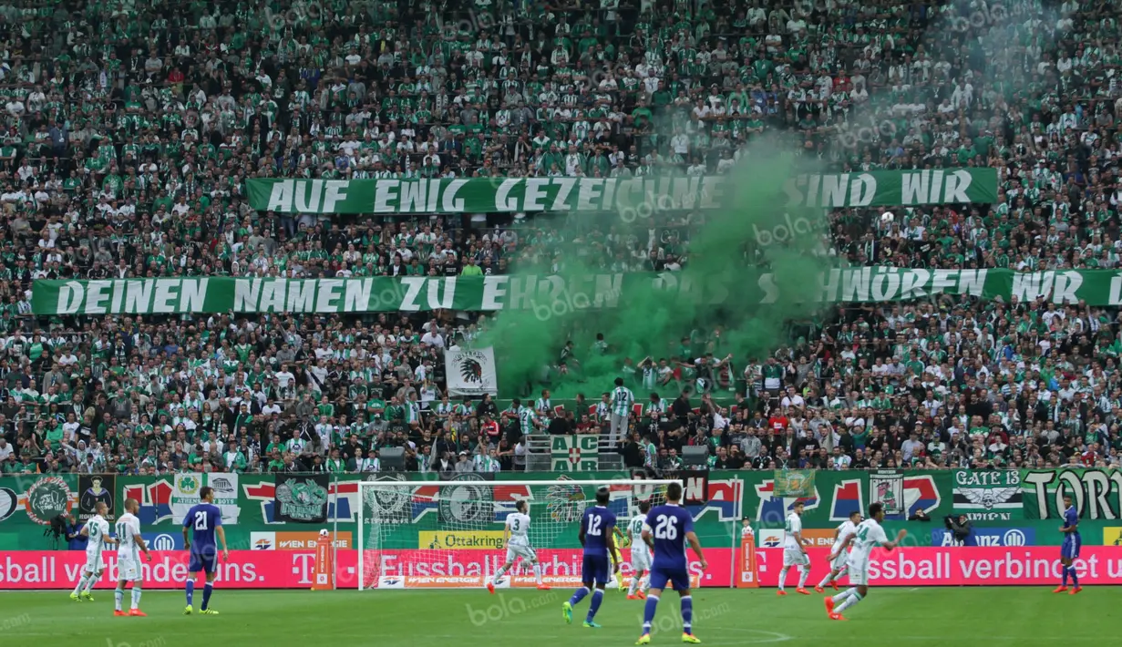 Fans Rapid Wien menyalakan bom asap di tengah berlangsungnya laga uji coba melawan Chelsea di Stadion Allianz, Sabtu (16/7/2016). (Bola.com/Reza Khomaini)