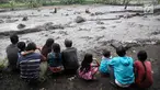 Warga mengamati aliran lahar dingin yang melintasi Sungai Yeh Sah di Karangasem, Bali, Sabtu (2/12). Banjir lahar dingin dari Gunung Agung tersebut mengundang perhatian warga sekitar. (Liputan6.com/Immanuel Antonius)