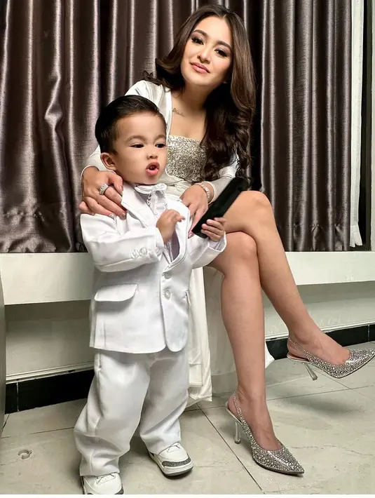 <p>Ibu satu anak ini pun tampil tanpa aksesori berlebih, hanya terlihat mengenakan cincin gelang serasi. Tampilannya semakin stunning dengan heels silver serasi dengan dressnya. [@nathalieholscher]</p>