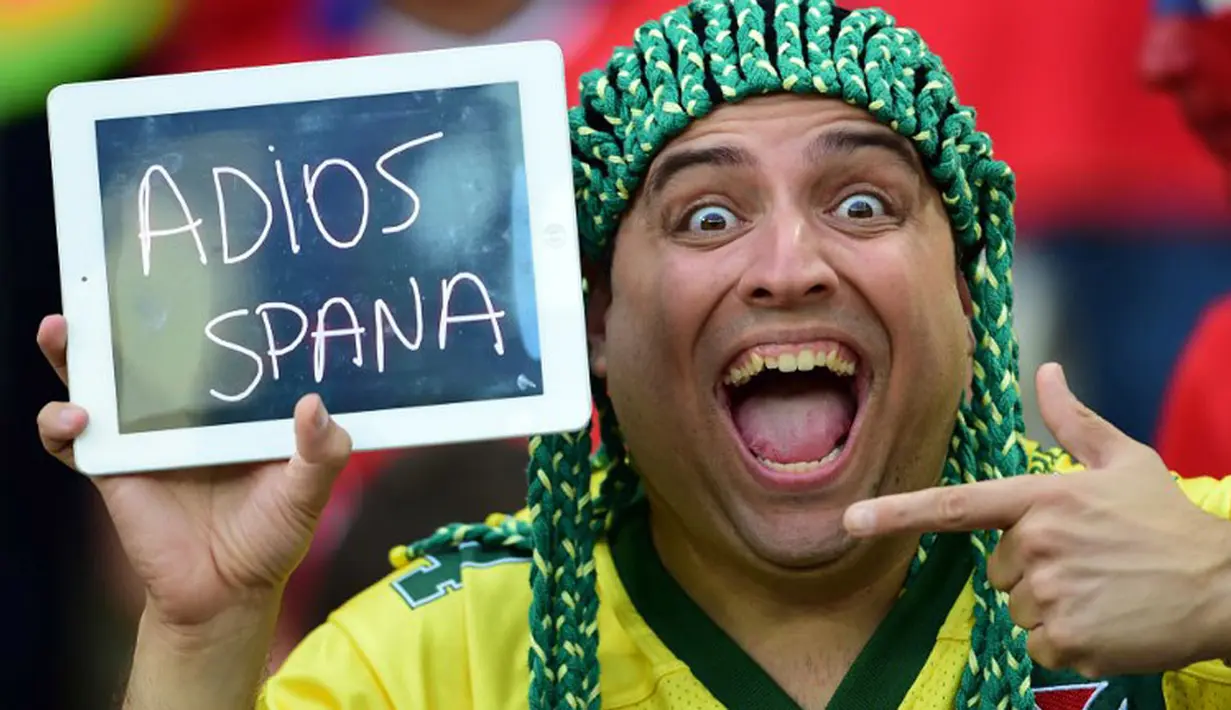 alah satu suporter Chili membawa tulisan "Selamat Jalan Spanyol" saat merayakan kemenangan La Roja atas Spanyol 2-0 di Stadion Maracana, Rio de Janeiro, Brasil, (19/6/2014). (AFP PHOTO/Martin Bernetti) 