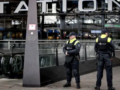 Aparat kepolisian berjaga di pintu masuk sebuah stasiun di Rotterdam, Senin (18/3). Pihak keamanan di Belanda meningkatkan keamanan di bandara dan bangunan penting lainnya usai penembakan di Utrecht yang menewaskan 3 orang.  (KOEN VAN WEEL/ANP/AFP)