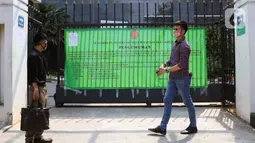 Warga melintas di depan pagar gedung Pengadilan Negeri Jakarta Pusat, Rabu (7/10/2020). Pengadilan Negeri Jakarta Pusat menghentikan aktivitas selama tiga hari terhitung Rabu 7 Oktober hingga 9 Oktober 2020 karena adanya hasil tes pegawai yang reaktif COVID-19. (Liputan6.com/Helmi Fithriansyah)