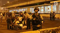 Sejumlah polisi berjaga di sekitar Terminal Kampung Melayu, Jakarta, Rabu (24/5). Polisi dari Polres Jakarta Timur dan Gegana Polda Metro Jaya tengah menyusuri lokasi ledakan. (Liputan6.com/Angga Yuniar)