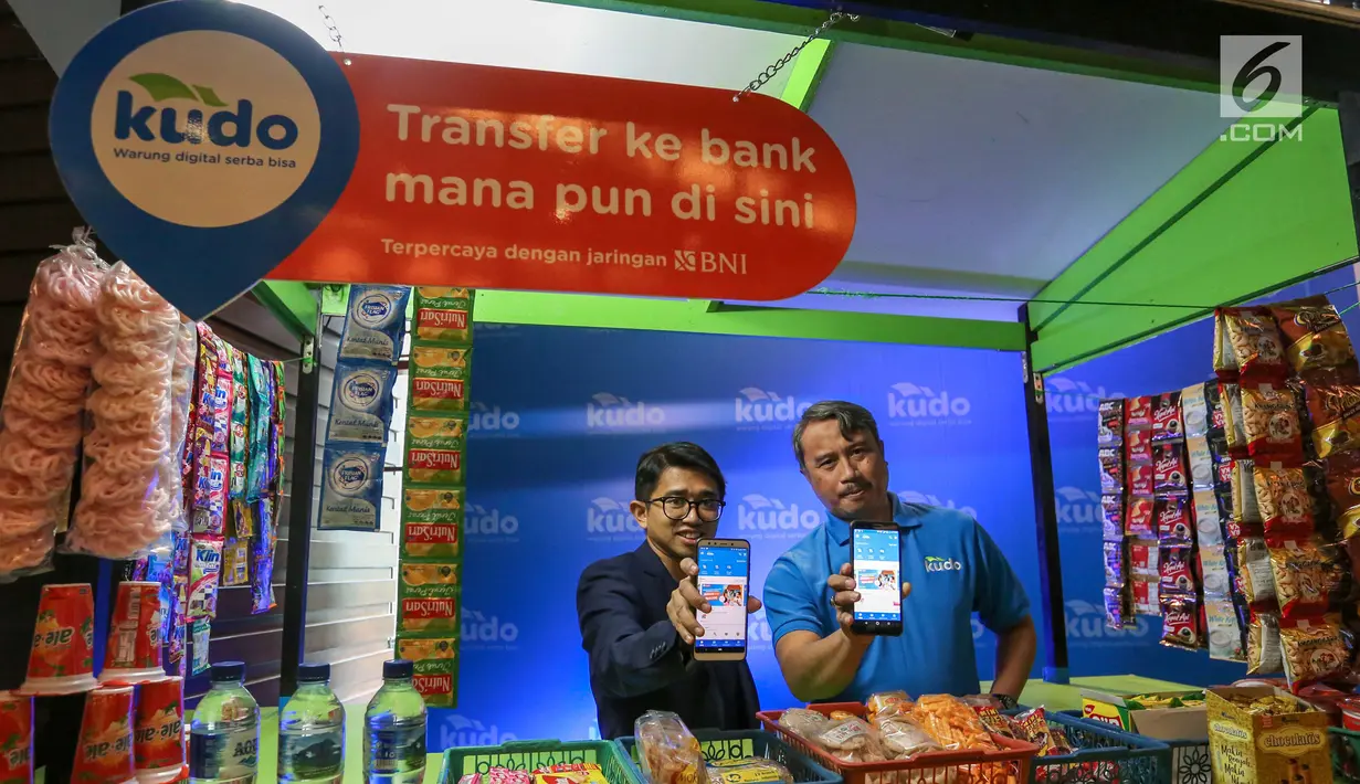 CEO & Co-Founder Kudo, Agung Nugroho (kiri) dan Agen Kudo, Dahlan (kanan) menunjukkan aplikasi digital Kudo di warung digital Jakarta, Kamis (27/6/2019). Sekitar 2 juta agen Kudo, memberikan akses yang terjangkau jutaan produk dan layanan online kepada jutaan pelanggan. (Liputan6.com/Fery Pradolo)
