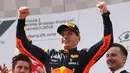 Pembalap Red Bull Max Verstappen tersenyum di podium setelah memenangkan Grand Prix Formula Satu Austria di Red Bull Racetrack di Spielberg, Austria selatan, (1/7). Verstappen mencatatkan waktu 1:21:56,024. (AP Photo / Ronald Zak)