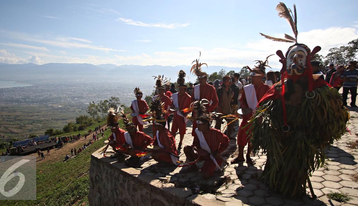 Seniman mementaskan tarian khas Toraja dan Dayak di Bukit Matantimali, Sigi, Sulawesi Tengah, Rabu (9/3). Tarian tersebut dilakukan dalam rangka menyambut gerhana matahari total serta menolak bala. (Liputan6.com/Immanuel Antonius)