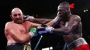 Deontay Wilder (kanan) dan Tyson Fury bertukar pukulan pada pertandingan tinju kelas berat WBC di T-Mobile Arena, Las Vegas, Nevada, Amerika Serikat, 9 Oktober 2021. Tyson Fury mempertahankan sabuk juara dunia tinju kelas berat WBC usai mengalahkan Deontay Wilder di ronde 11.(AP Photo/Chase Stevens)