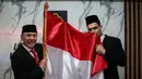 <p>Pemain Naturalisasi Timnas Indonesia, Shayne Pattynama (kanan) mencium bendera merah putih bersama Ketua Umum PSSI saat Pengambilan Sumpah Janji Setia Pewarganegaraan Republik Indonesia yang berlangsung di Kantor Wilayah Kementetian Hukum dan HAM DKI Jakarta, Selasa (24/01/2023). (Bola.com/Bagaskara Lazuardi)</p>