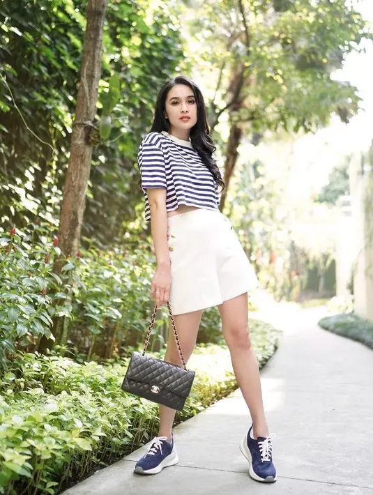 Gaya kasual berikutnya yang bisa kamu tiru adalah OOTD ala Sandra Dewi berikut ini. Kombinasikan stripe tee dengan short pants dan sneakers. (Instagram/sandradewi88).