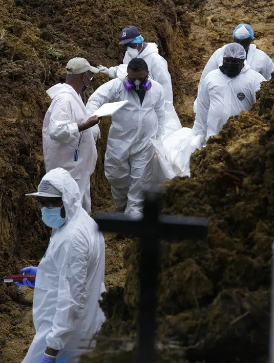 Tim forensik menguburkan secara massal sekelompok imigran yang tewas saat mencoba menyeberangi Celah Darien di Pemakaman Guayabillo, Agua Fria, Panama, 30 September 2021. Celah Darien berupa lembah dan rawa-rawa di Amerika Tengah yang memutus Jalan Pan Amerika. (AP Photo/Arnulfo Franco)
