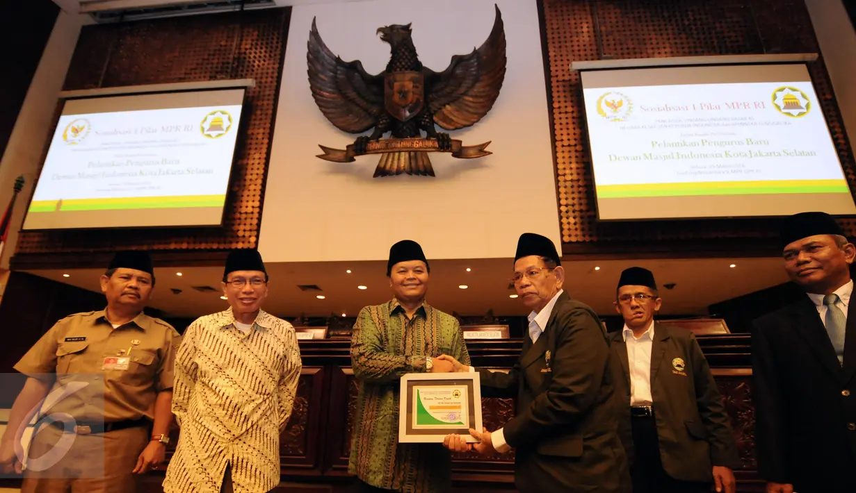 Wakil Ketua MPR RI Hidayat Nur Wahid (ketiga kiri) bertukar cenderamata bersama pengurus baru DMI Jakarta Selatan jelang memberikan materi Sosialisasi 4 Pilar MPR RI di Kompleks Parlemen RI, Jakarta, Selasa (29/3/2016). (Liputan6.com/Helmi Fithriansyah)