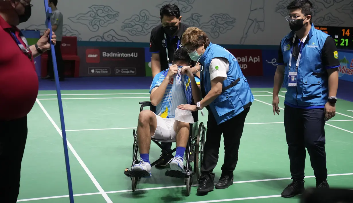<p>Ganda putra Indonesia Yeremia Rambitan meninggalkan lapangan dengan kursi roda saat perempat final dengan rekannya Pramudya Kusumawardana melawan pasangan Malaysia Aaron Chia/Soh Wooi Yik di Istora Senayan, Jakarta, Jumat (17/6/2022). Tepuk tangan penghormatan diberikan pada Yeremia yang telah berjuang keras menyelesaikan pertandingan. (AP Photo/Dita Alangkara)</p>