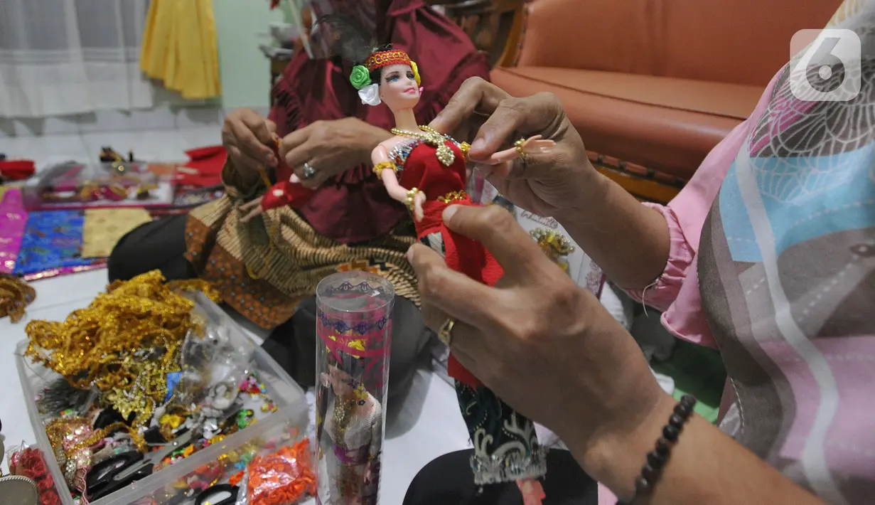 Ibu rumah tangga menyelesaikan pembuatan boneka adat Indonesia di Ammie Dolls di Komplek Pondok Tirta, Depok, Kamis (13/08/2020). Pada masa pandemi ini produksi dan penjualan anjlok hingga 95 persen menyebabkan perajin beralih ke bidang lain untuk mencukupi kebutuhan hidup. (merdeka.com/Arie Basuki)