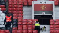   Petugas keamanan bersama anjing pelacak bom terlihat menyisir beberapa bagian stadion Old Trafford setelah ditemukan paket mencurigakan menjelang laga Manchester United melawan Bournemouth, Minggu (15/5/2016). (AFP/Oli Scarff). 