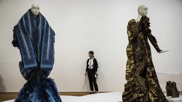 Gaun (kiri) dari koleksi Haute Couture Dior Musim Semi/Musim Panas 2003 karya John Galliano dan gaun (kanan) dari koleksi Haute Couture Legend of the Dragon 2012 karya Guo Pel terlihat dalam pameran 'Madame Song: Pioneering Art and Fashion in China' di mu