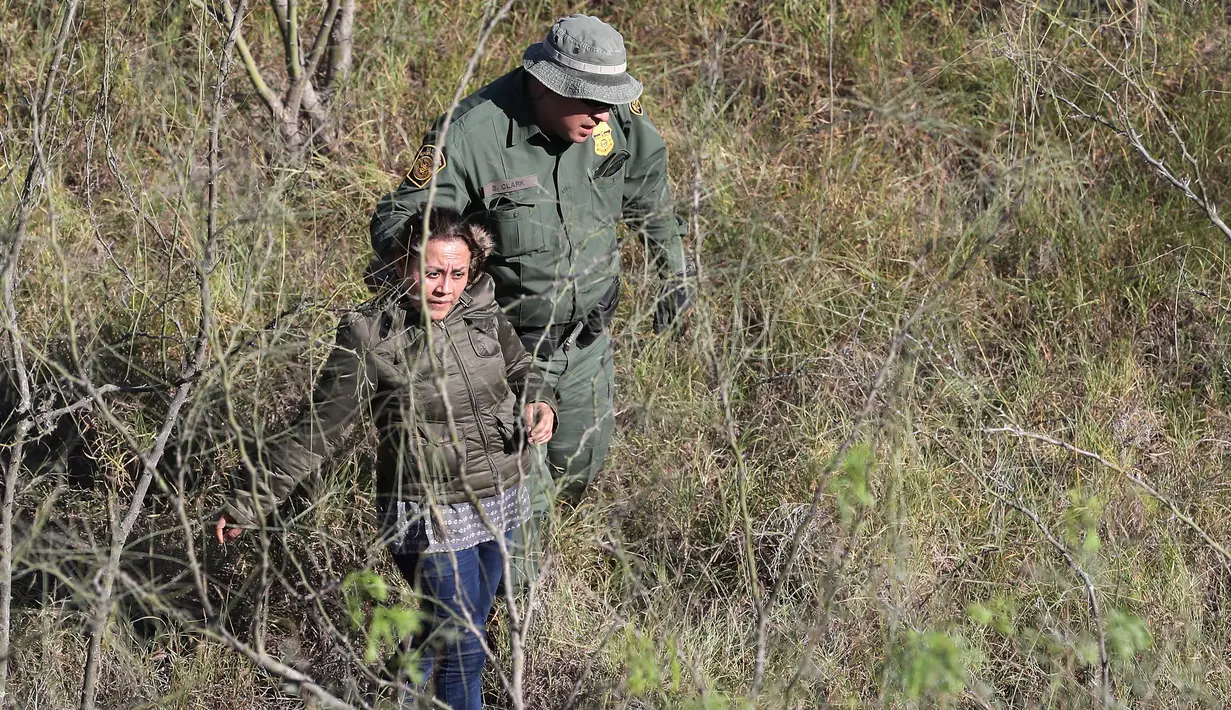 Petugas patroli perbatasan AS menangkap seorang imigran tanpa dokumen di dekat perbatasan AS-Meksiko di Mission, Texas (3/1). Ribuan imigran gelap nekat masuk perbatasan AS-Meksiko jelang pelantikan Donald Trump. (AFP Photo/John Moore/Getty Images)
