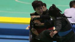 Pesilat Indonesia, Octaviani Nirmalasari (kiri) menahan tendangan pesilat Laos, Olahthai Sounthavong pada semifinal Test Event Pencak Silat 2018 di Padepokan Silat TMII, Jakarta, (12/2/2018). Oktaviani menang 5-0. (Bola.com/Nick Hanoatubun)