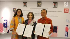 Chief Marketing Officer DOKU, Himelda Renuat, Chief Operating Officer DOKU, Nabilah Alsagoff dan Dirjen Dukcapil Zudan Arif Fakrulloh menunjukkan perjanjian kerja sama pemanfaatan data kependudukan di Jakarta, Jumat (11/1). (Liputan6.com/Fery Pradolo)