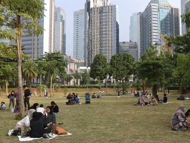 Warga menikmati suasana menjelang sore di Hutan Kota Gelora Bung Karno (GBK), Jakarta, Minggu (17/10/2021). Hutan Kota mulai dibuka secara umum dengan memberlakukan pembatasan sebanyak 150 orang dengan batas waktu satu jam kunjungan. (Liputan6.com/Herman Zakharia)