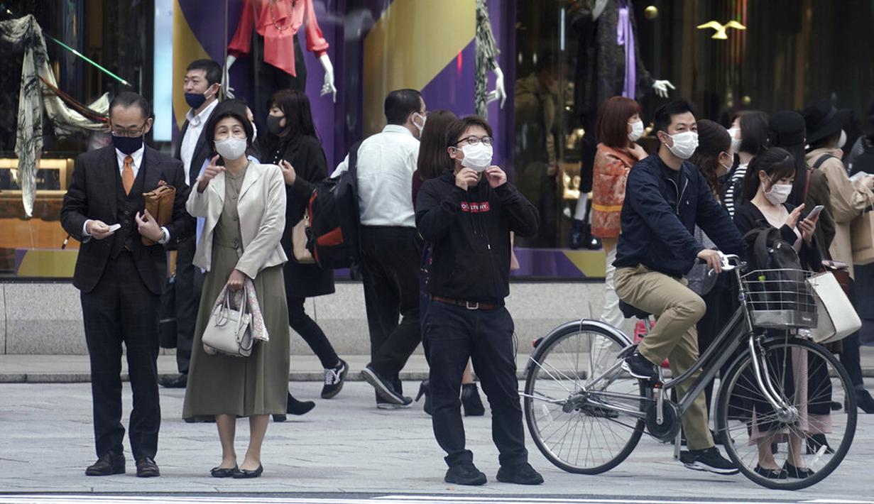 Orang-orang yang mengenakan masker untuk membantu mengekang penyebaran virus corona COVID-19 menunggu untuk menyeberang jalan di Tokyo, Jepang, Rabu (28/10/2020). Tokyo mengonfirmasi lebih dari 170 kasus virus corona COVID-19 baru pada 28 Oktober 2020. (AP Photo/Eugene Hoshiko)