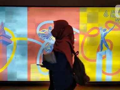 Seorang pengunjung melintas saat mengunjungi pameran Jakarta Film Week 2022 hari kedua di CGV Grand Indonesia, Jakarta, Jumat (14/10/2022). Jakarta Film Week merupakan festival film internasional yang berbasis di Jakarta. selain bisa dihadiri secara langsung selama festival berlangsung, festival ini dapat dinikmati pecinta film di seluruh Indonesia secara daring. (Liputan6.com/magang/Aida Nuralifa)