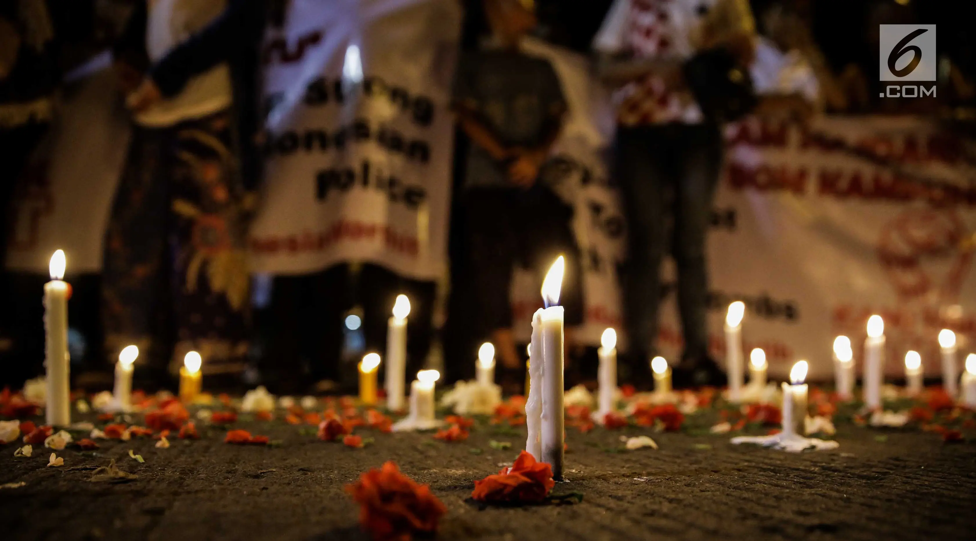 assa dari Solidaritas Merah Putih menggelar aksi lilin dan tabur bunga di lokasi bom Terminal Kampung Melayu, Jakarta, Kamis (25/5). Aksi tersebut sebagai bentuk malam solidaritas duka untuk bom Kampung Melayu.(Liputan6.com/Faizal Fanani)