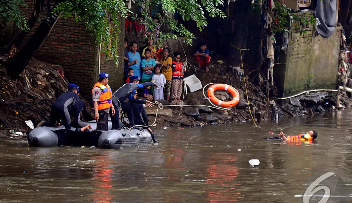 Petugas melemparkan pelampung kepada warga yang hanyut dalam simulasi penyelamatan saat banjir, Kampung Pulo, Jakarta, Selasa (13/1/2015). (Liputan6.com/Johan Tallo)