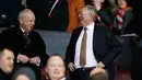 Sir Alex Ferguson berbincang dengan rekannya saat menyaksikan pertandingan antara Manchester United dengan Chelsea di Stadion Old Trafford, Inggris (28/12). MU bermain imbang dengan Chelsea dengan skor 0-0. (Reuters/Phil Noble)