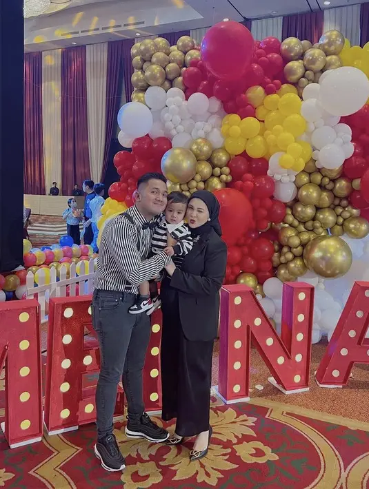 Kesha Ratuliu tampol dengan setelah blazer dan kerudung hitam. Lalu suami dan anaknya kompak mengenakan pakaian bergaris.  (@kesharatuliu05)