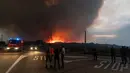 Petugas pemadam kebakaran, polisi, dan warga menyaksikan kebakaran hutan yang berkobar di Pumarejo de Tera dekat Zamora, Spanyol, 18 Juni 2022. Kebakaran hutan terbesar masih di luar kendali sore ini di Sierra de la Culebra, sebuah pegunungan di wilayah Castile dan Leon (barat laut), dekat perbatasan dengan Portugal. (CESAR MANSO/AFP)
