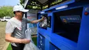 Turis memasukkan sampah ke bank sampah di Teluk Mulan, Kota Wenchang, Provinsi Hainan, China, 28 April 2020. Fasilitas bank sampah dibuat dengan wisatawan menukarkan sampah yang mereka kumpulkan di pantai dengan berbagai hadiah, seperti air kemasan, kelapa, serta makanan ringan. (Xinhua/Guo Cheng)