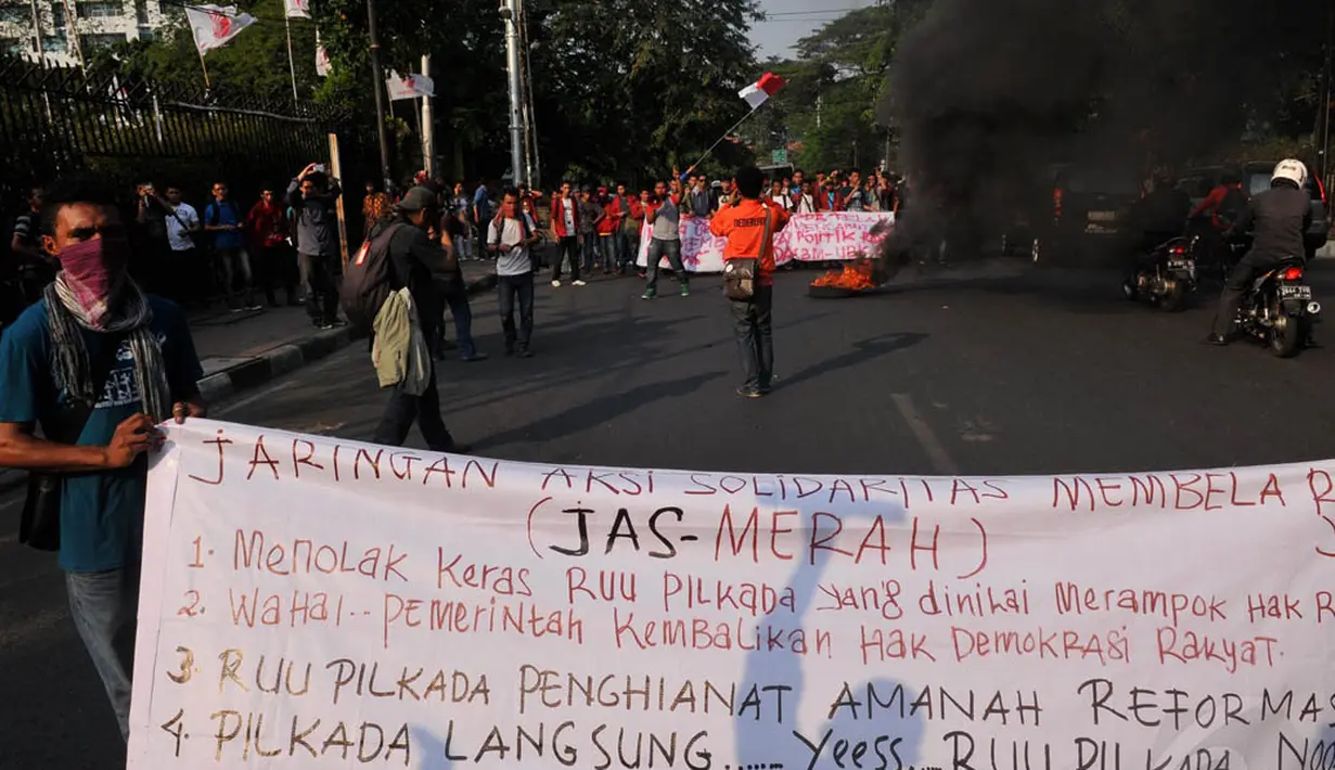 Puluhan massa yang tergabung dalam Jaringan aksi Solidaritas Membela Rakyat (JAS MERAH) membentangkan spanduk yang berisi tuntutan pembatalan UU Pilkada, Jakarta, (2/10/14). (Liputan6.com/Johan Tallo)