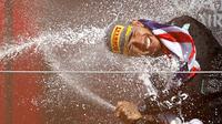 Pembalap Mercedes, Lewis Hamilton merayakan kemenangannya di Formula 1 GP Inggris 2024 yang berlangsung di Sirkuit Silverstone, Inggris, Minggu (08/07/2024). (AFP/Benjamin Cremel)