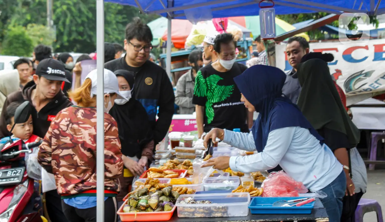 Pedagang melayani pembeli takjil menjelang waktu berbuka puasa di sepanjang Jalan Panjang, Kebon Jeruk, Jakarta, Selasa (4/4/2023). (Liputan6.com/Johan Tallo)