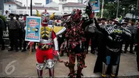 Sejumlah buruh mengenakan kostum cosplay super hero ketika berunjuk rasa di depan Balai Kota, Jakarta, Kamis (29/9). Dalam aksinya, buruh menuntut kenaikan upah mininum Rp 650ribu dan penghapusan Tax Amnesty. (Liputan6.com/Faizal Fanani)