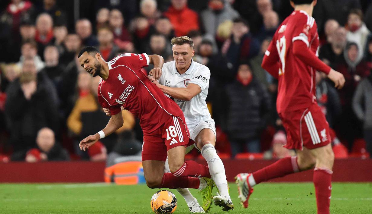 Laga yang berlangsung pada Senin 12 Januari 2026 waktu setempat atau Selasa (13/1/2026) dini hari WIB berjalan cukup mengejutkan. Tampak dalam foto, bek Barnsley asal Inggris, Jack Shepherd melakukan pelanggaran terhadap striker Liverpool asal Belanda, Cody Gakpo saat pertandingan putaran ketiga Piala FA Inggris di Stadion Anfield, pada Senin 12 Januari 2026 waktu setempat atau Selasa (13/1/2026) dini hari WIB. (PETER POWELL/AFP)
