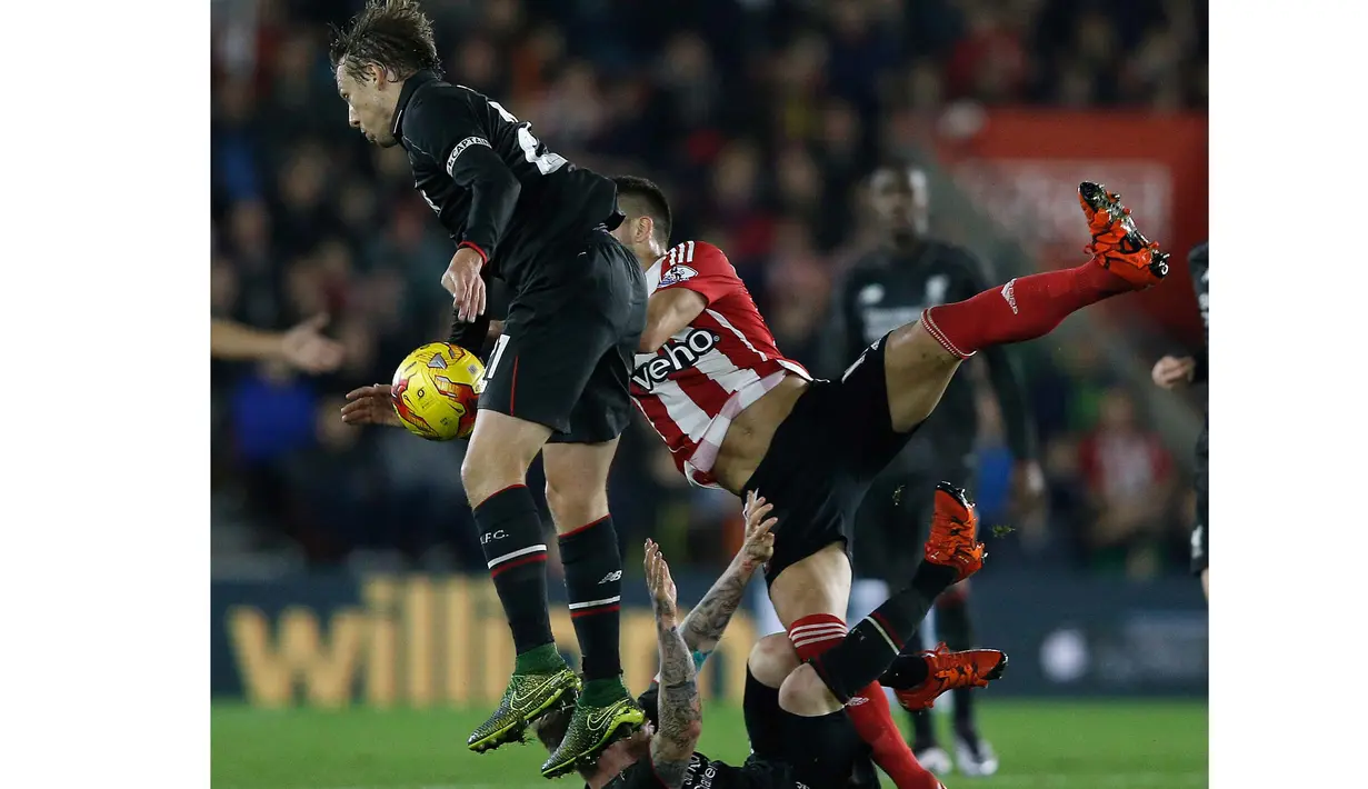 Pemain Liverpool, Lucas Leiva (kiri) berduel dengan pemain Southampton,  Dusan Tadic (kanan) pada laga Piala Liga Inggris di Stadion St. Mary's; Southampton; Kamis (3/12/2015) dini hari WIB. (AFP Photo/Adrian Dennis)