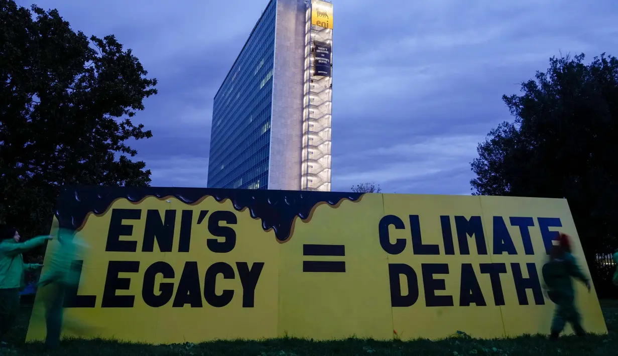 Aktivis organisasi lingkungan Greenpeace membuka spanduk di samping gedung kantor pusat ENI—perusahaan minyak dan gas Italia—di Roma, Selasa, 5 Desember 2023. (AP Photo/Andrew Medichini)