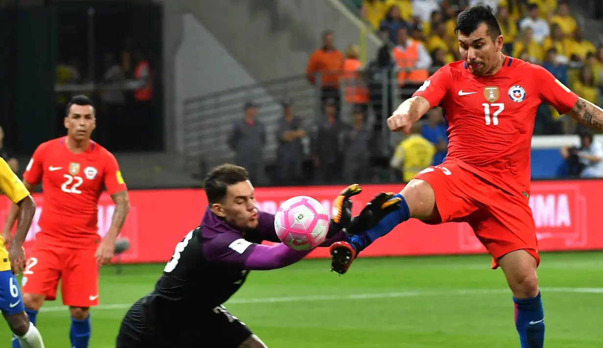 Gelandang Cile, Gary Medel, berebut bola dengan kiper Brasil, Ederson, pada laga kualifikasi Piala Dunia 2018 di Stadion Allianz Parque, Sao Paulo, Selasa (10/10/2017). Brasil menang 3-0 atas Cile. (AFP/Nelson Almeida)