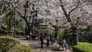Taman-taman di Tokyo, seperti Ueno, Shinjuku Gyoen, dan Sumida Park menjadi pusat perhatian dengan ribuan pohon. Tampak dalam foto, orang-orang memotret bunga sakura di sebuah taman di Tokyo pada Senin 30 Maret 2026. (Yuichi YAMAZAKI/AFP)