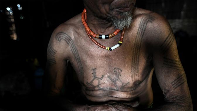 Ngon Pok (80), seorang suku Lainong yang bertato saat berada di rumahnya di Kota Lahel, Sagaing, Myanmar, 6 Februari 2020. Suku-suku tersebut menjalin kepercayaan animisme mereka dengan tradisi prajurit yang mencakup desain tato mencolok. (Ye Aung THU/AFP)