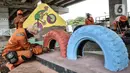 Petugas PPSU menyelesaikan ornamen rambu lalu lintas di Taman Pilar Jati, Kolong Tol Becakayu, Jakarta, Selasa (8/9/2020). Taman yang dibangun atas inisiasi petugas PPSU Kelurahan Cipinang Melayu itu akan dilengkapi trek sepeda dan dihiasi ornamen edukasi anak. (merdeka.com/Iqbal S. Nugroho)