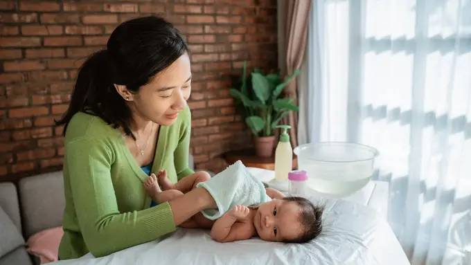 membersihkan tubuh bayi